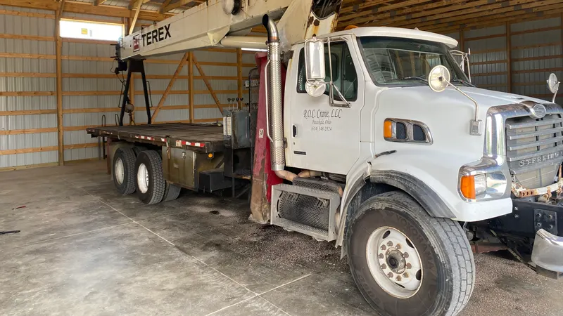 ROC Crane's 23 ton boom truck, boom stowed over its flat deck.